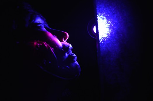 Marcela's face lit by a purple light.